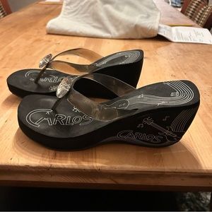 Black platform sandals with a clear strap thru toes, and pendant. Size 9